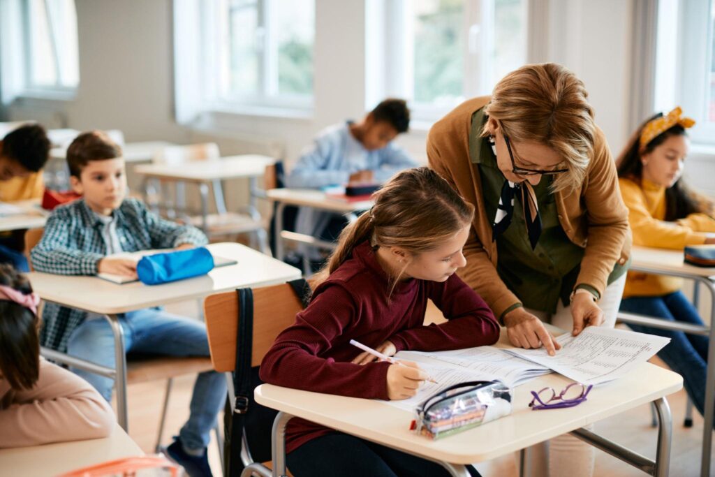Teacher providing one-on-one support to a student in a classroom
