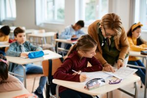 Teacher providing one-on-one support to a student in a classroom